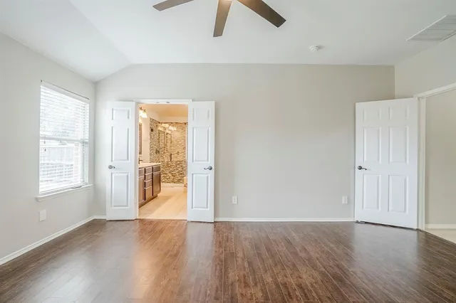 an empty room with wooden floor and window
