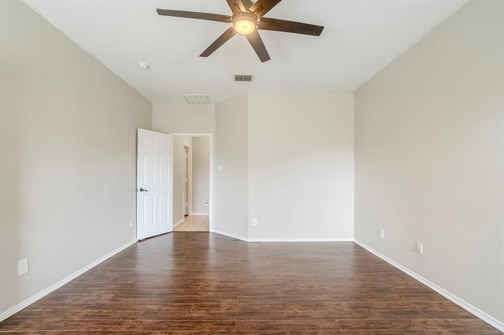 1109 Johnson City Avenue Forney, TX 75126 - Photo 25 of 40 a view of an empty room with wooden floor and a ceiling fan