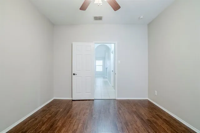 an empty room with wooden floor and mirror