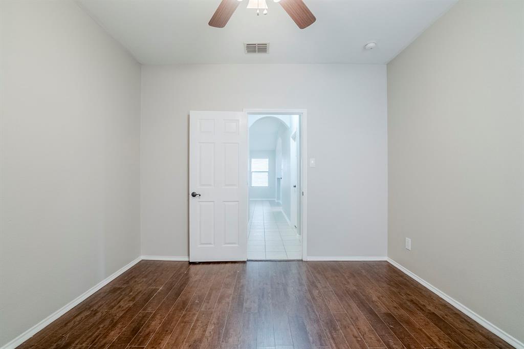 1109 Johnson City Avenue Forney, TX 75126 - Photo 32 of 40 an empty room with wooden floor and mirror