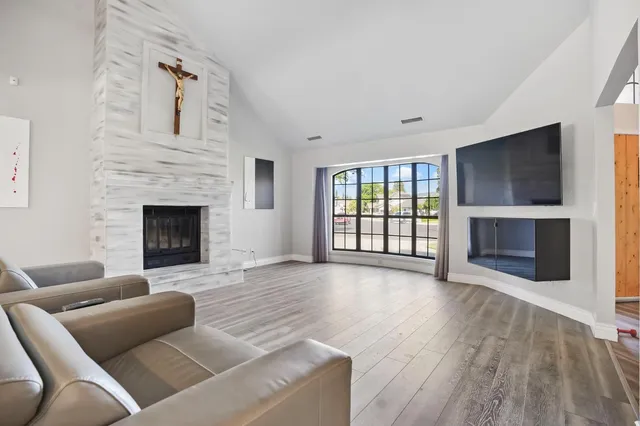 a living room with fireplace furniture and a wooden floor