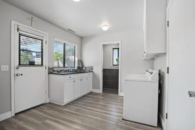 a kitchen with white cabinets and sink