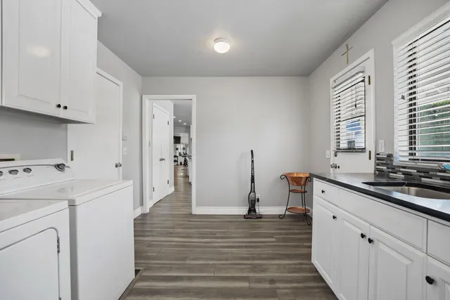 a kitchen with granite countertop a refrigerator and white cabinets
