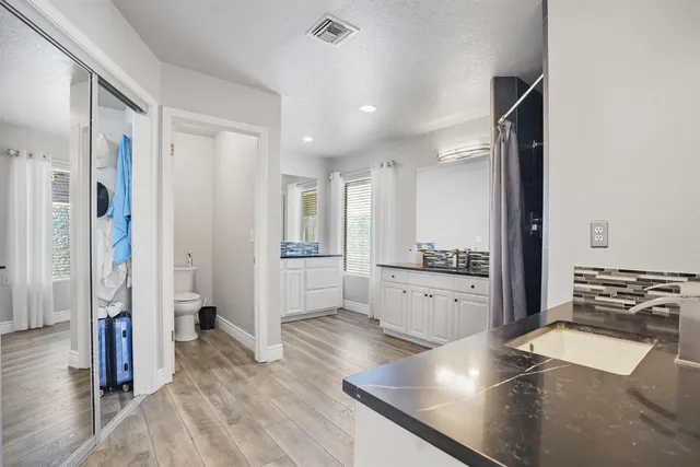 a bathroom with a granite countertop sink a mirror and a shower