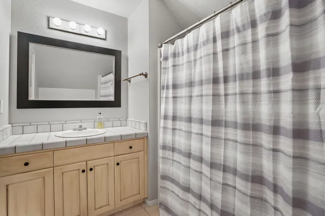 an empty room with chandelier fan and windows