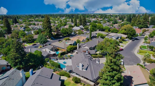 an aerial view of residential houses with outdoor space and swimming pool