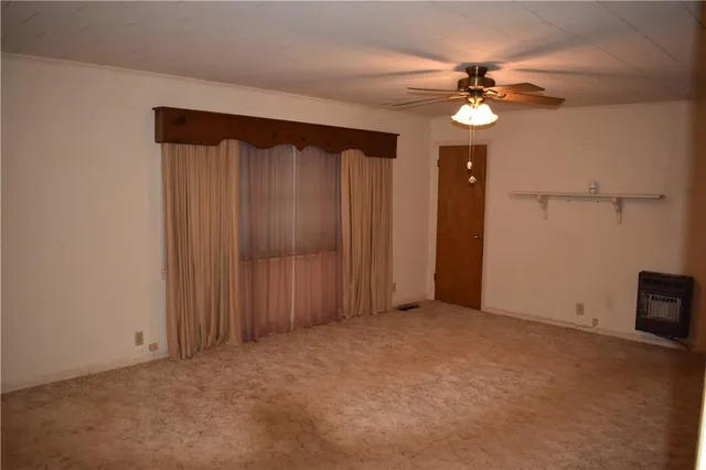 a view of an empty room with a chandelier fan