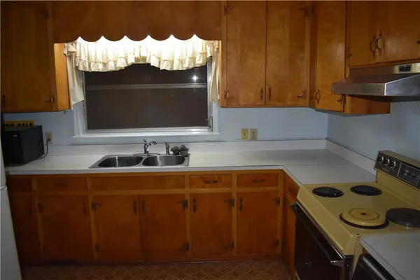 a kitchen with white cabinets and a stove
