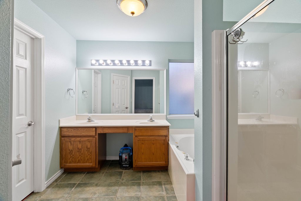7510 Geiger Drive Corpus Christi, TX 78414 - Photo 13 of 15 a spacious bathroom with a granite countertop sink a mirror and a bathtub