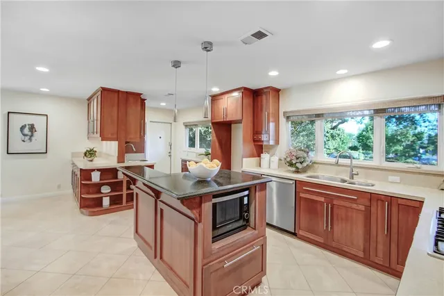 a kitchen with stainless steel appliances granite countertop a stove a sink and a refrigerator