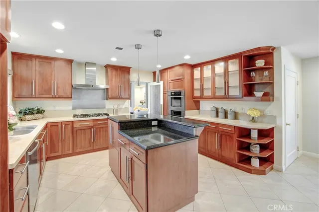 a kitchen with stainless steel appliances granite countertop a stove refrigerator and a sink