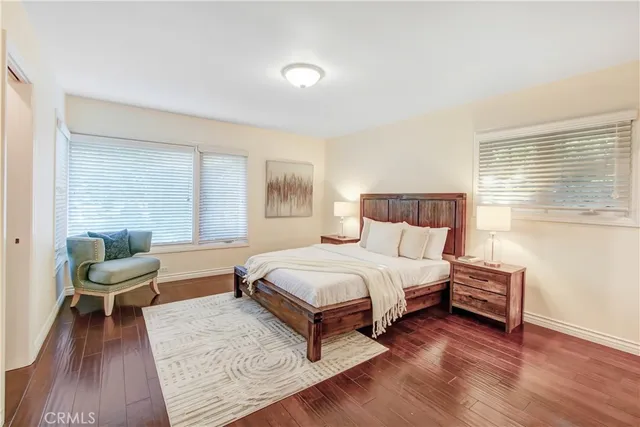 a bedroom with a bed painting on the wall and a window