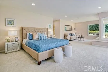 a spacious bedroom with a bed a table and chair