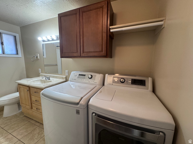 2182 West 5600th Street South Roy, UT 84067 - Photo 10 of 11 Laundry area featuring a side-by-side washer and dryer, adjacent to a vanity with an integrated sink and base cabinetry