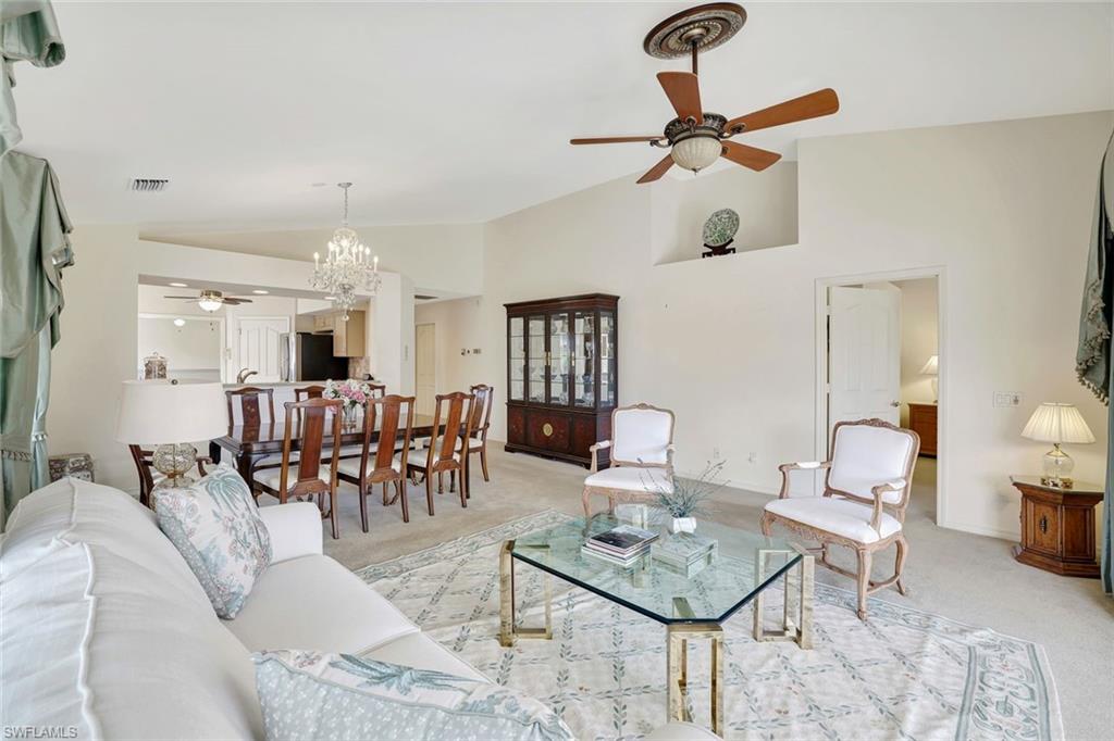 6200 Reserve Circle, Unit 404 Naples, FL 34119 - Photo 13 of 47 a living room with furniture a rug and a chandelier