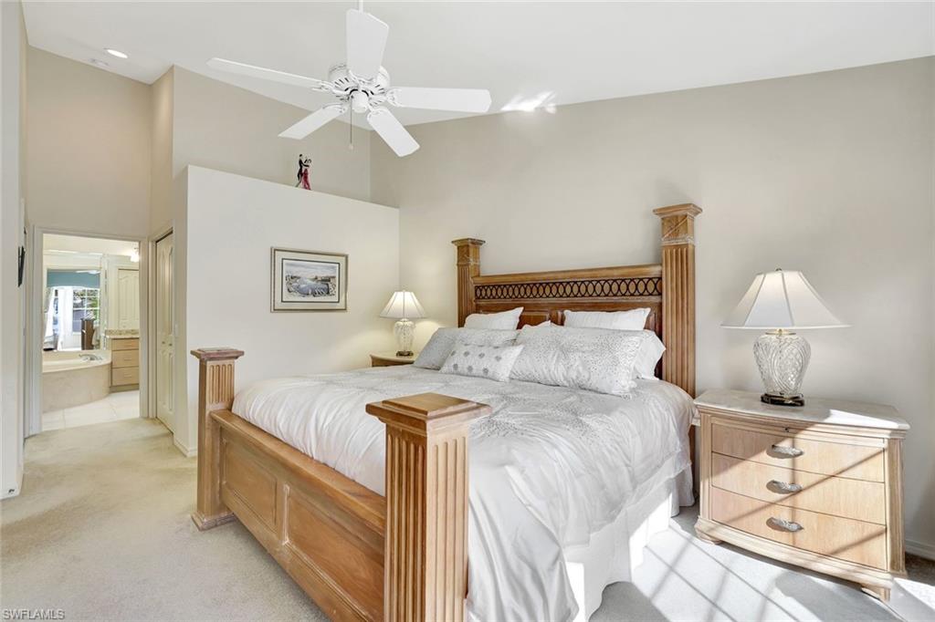 6200 Reserve Circle, Unit 404 Naples, FL 34119 - Photo 20 of 47 Sunlit primary bedroom featuring ensuite bathroom, a towering ceiling, ceiling fan, and a walk-in closet and second closet.