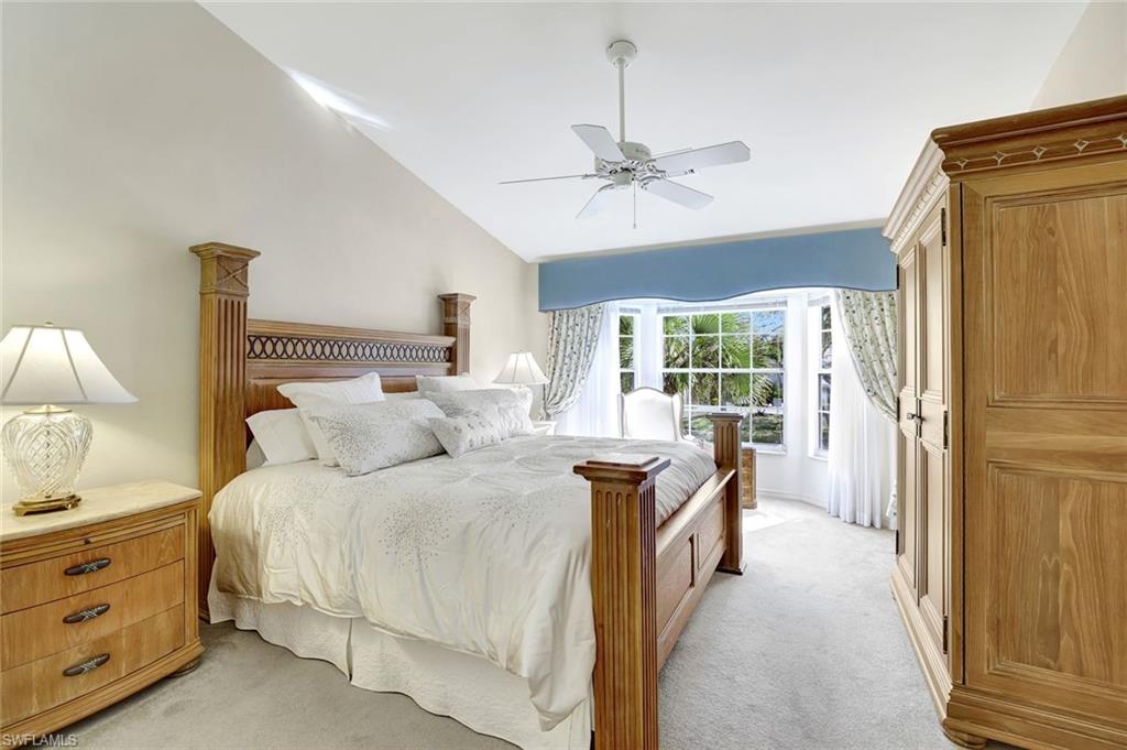 6200 Reserve Circle, Unit 404 Naples, FL 34119 - Photo 21 of 47 a bedroom with a bed and a chandelier