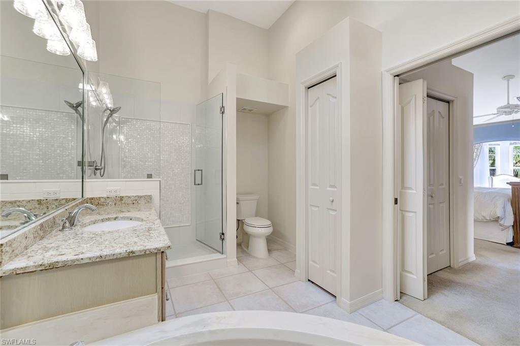 6200 Reserve Circle, Unit 404 Naples, FL 34119 - Photo 23 of 47 a spacious bathroom with a granite countertop sink a toilet and a large mirror