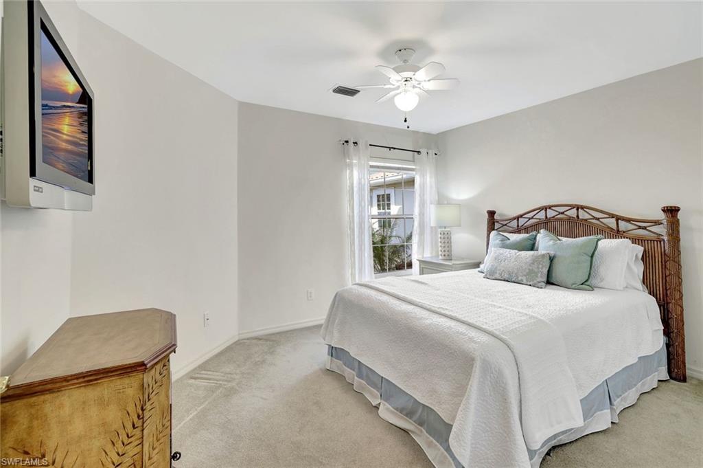 6200 Reserve Circle, Unit 404 Naples, FL 34119 - Photo 24 of 47 a bedroom with a bed and a chandelier