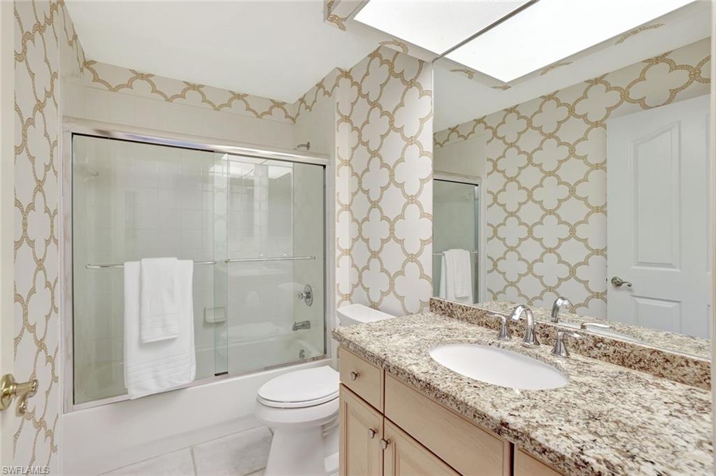 6200 Reserve Circle, Unit 404 Naples, FL 34119 - Photo 25 of 47 a bathroom with a granite countertop sink toilet and shower