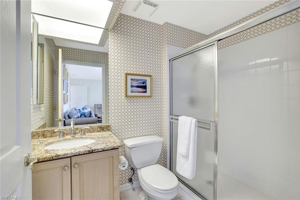 6200 Reserve Circle, Unit 404 Naples, FL 34119 - Photo 28 of 47 a bathroom with a granite countertop sink toilet and shower