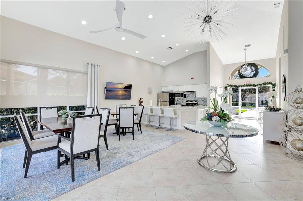 6200 Reserve Circle, Unit 404 Naples, FL 34119 - Photo 40 of 47 a room with stainless steel appliances kitchen island granite countertop lots of white furniture a dining table and chairs