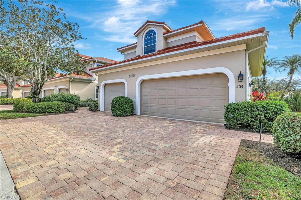 6200 Reserve Circle, Unit 404 Naples, FL 34119 - Photo 7 of 47 a front view of a house with garden