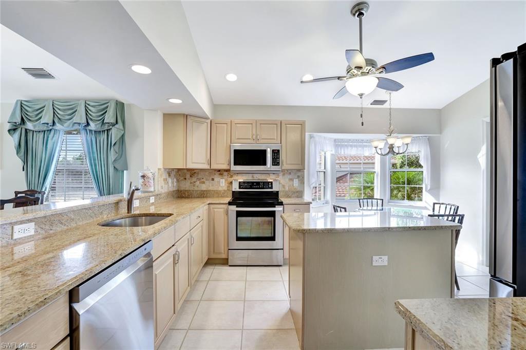 6200 Reserve Circle, Unit 404 Naples, FL 34119 - Photo 9 of 47 a kitchen with stainless steel appliances granite countertop a sink and a stove