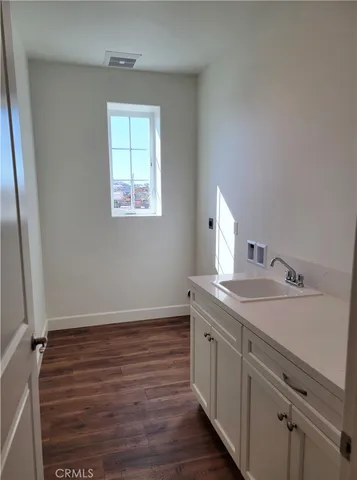 a room with a sink cabinets and a window