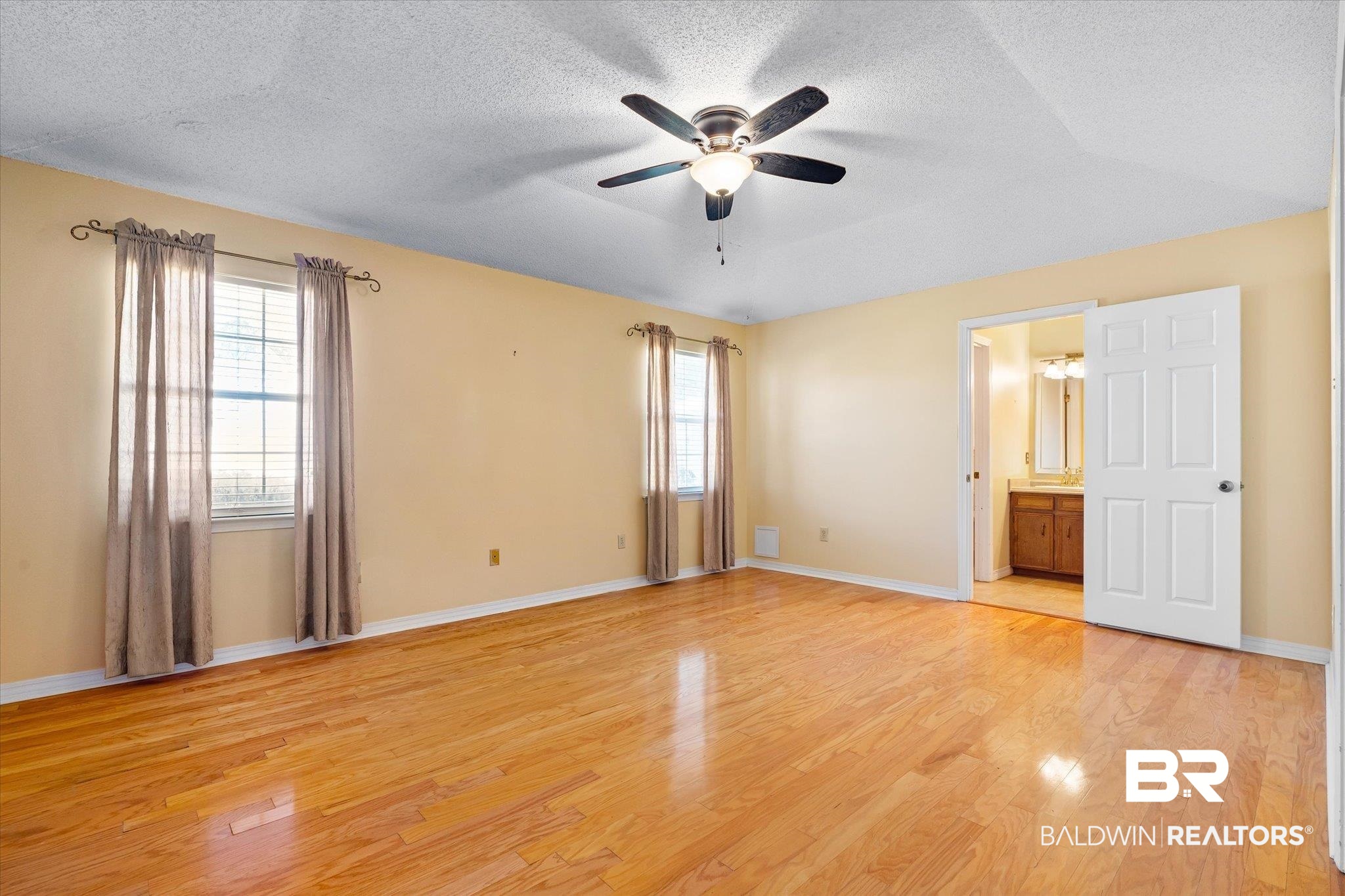 7200 Pine Station Road South Mobile, AL 36695 - Photo 24 of 29 Unfurnished bedroom featuring light wood-type flooring, a textured ceiling, connected bathroom, and ceiling fan