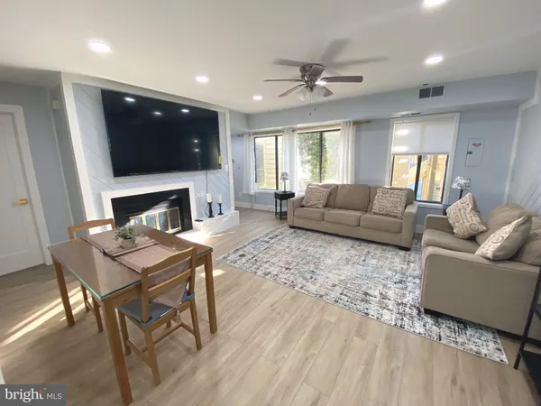 a living room with furniture a flat screen tv and a fireplace