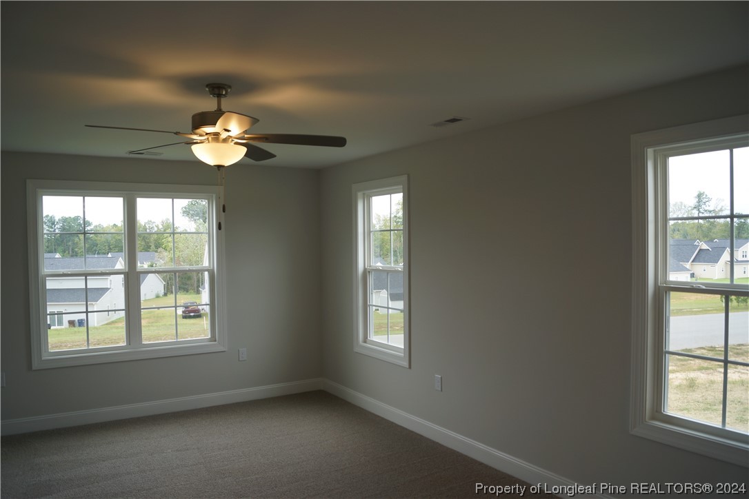 103 Grinnel Loop Sanford, NC 27332 - Photo 22 of 39 an empty room with windows and ceiling fan