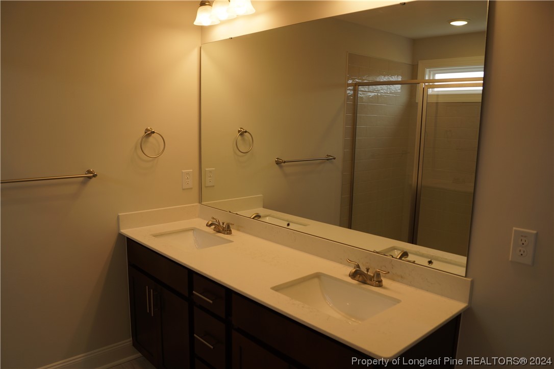 103 Grinnel Loop Sanford, NC 27332 - Photo 24 of 39 a bathroom with a sink vanity and a mirror
