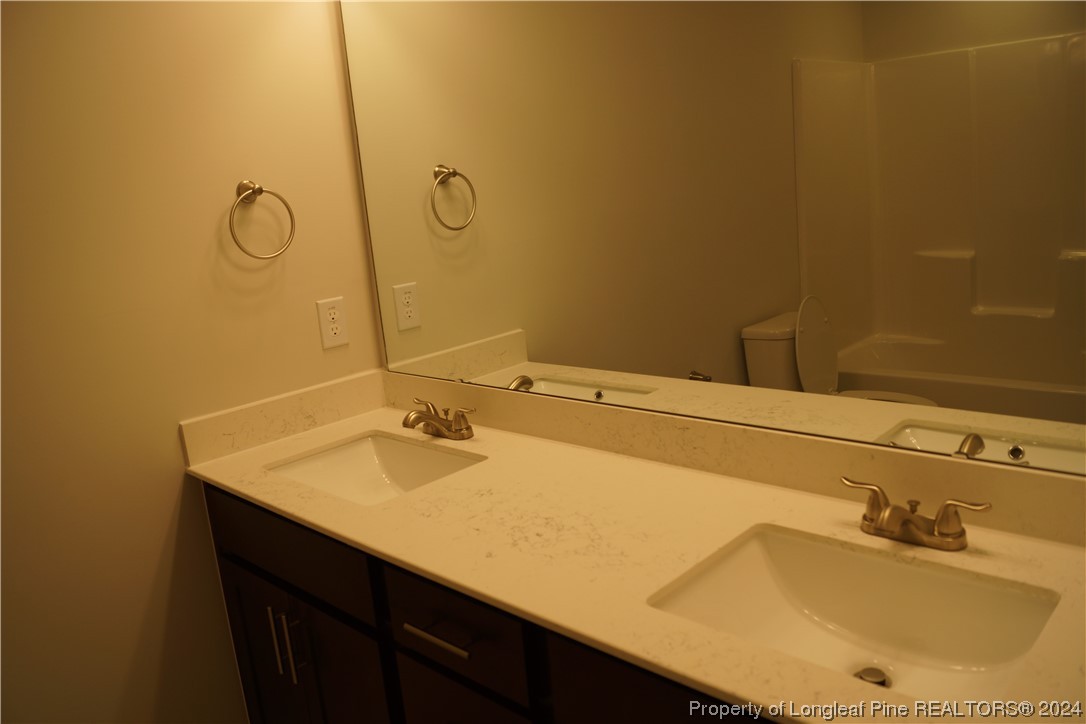 103 Grinnel Loop Sanford, NC 27332 - Photo 30 of 39 a bathroom with a sink and a mirror