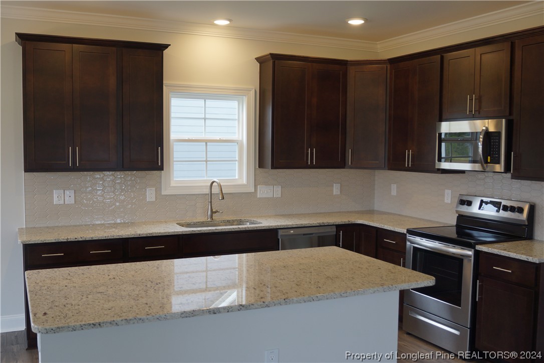103 Grinnel Loop Sanford, NC 27332 - Photo 5 of 39 a kitchen with a sink and a stove top oven