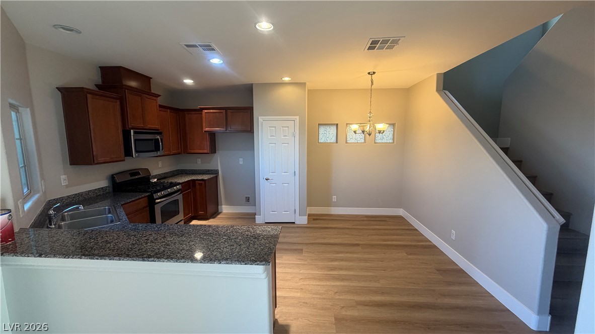 9453 Alma Ridge Avenue Las Vegas, NV 89178 - Photo 4 of 25 A streamlined kitchen layout flows into a flexible dining space with wood-style flooring.