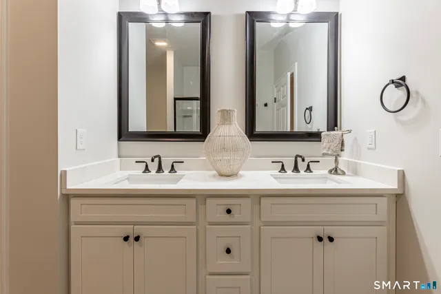 a bathroom with double sink and a mirror