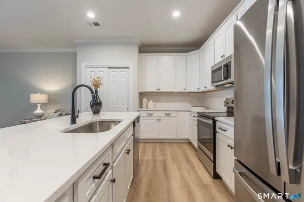 a kitchen with a sink cabinets and stainless steel appliances