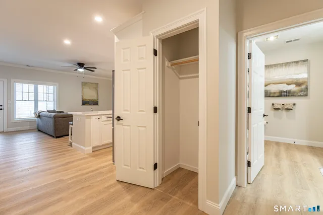a view of a hallway with wooden floor and a living room