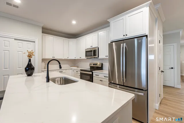 a kitchen with stainless steel appliances a refrigerator stove microwave and sink