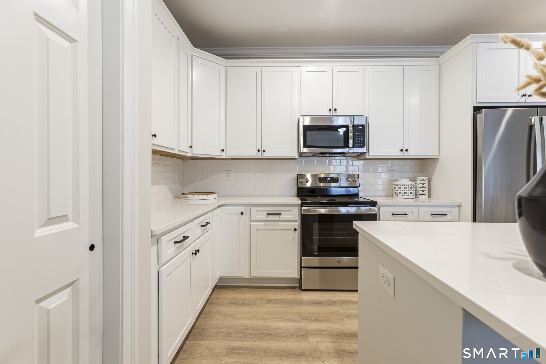 7 Loomis Road, Unit C Bolton, CT 06043 - Photo 6 of 26 a kitchen with white cabinets and stainless steel appliances