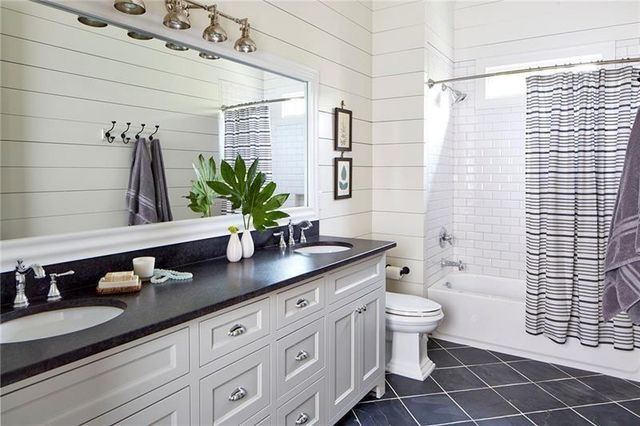 a bathroom with a granite countertop sink a toilet a mirror and shower