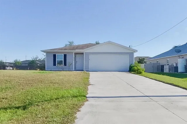 a front view of a house with a garden and yard