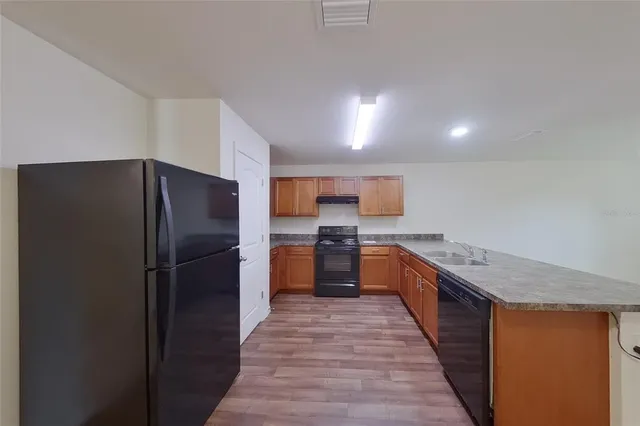 a kitchen with stainless steel appliances granite countertop a refrigerator and a stove