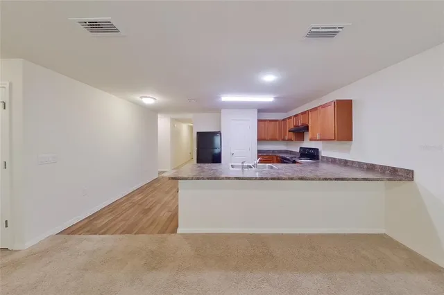 a view of kitchen and kitchen with granite countertop sink