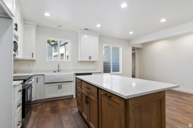 504 North 650 E Street Springville, UT 84663 - Photo 27 of 36 Open-concept kitchen featuring an island with a light-colored countertop, white shaker cabinetry with dark hardware, a farmhouse-style sink, and recessed lighting