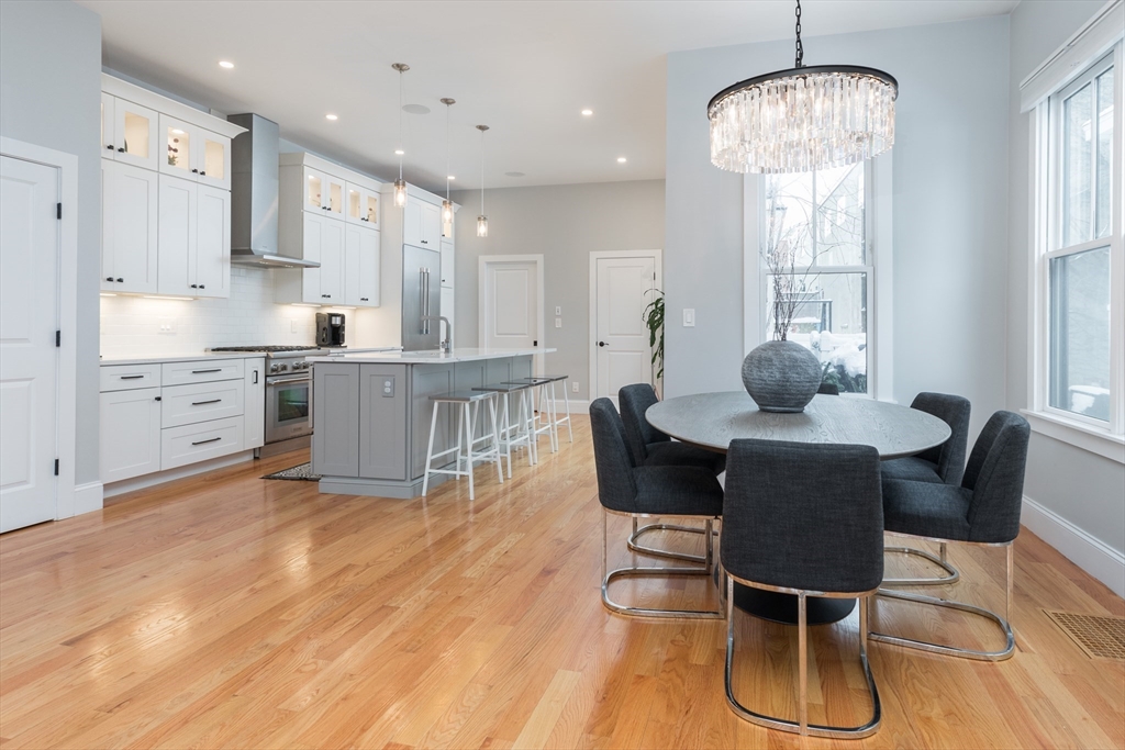 a kitchen with granite countertop a dining table chairs and white cabinets