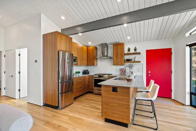a kitchen with granite countertop a refrigerator and a stove top oven