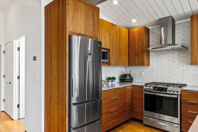 a kitchen with stainless steel appliances granite countertop a refrigerator a stove and a sink
