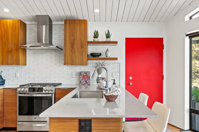 a kitchen with granite countertop a sink stove and refrigerator